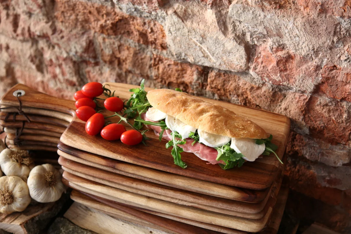 Panino Cesarino con mozzarella, pomodori e basilico su un tagliere