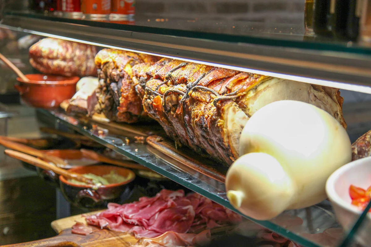 Porchetta e formaggi nel banco delle specialità di Cesarino